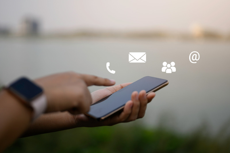Businessman using a mobile phone with floating icons in the air
